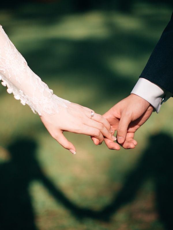 Brautpaar unter einem Blumenbogen im Garten